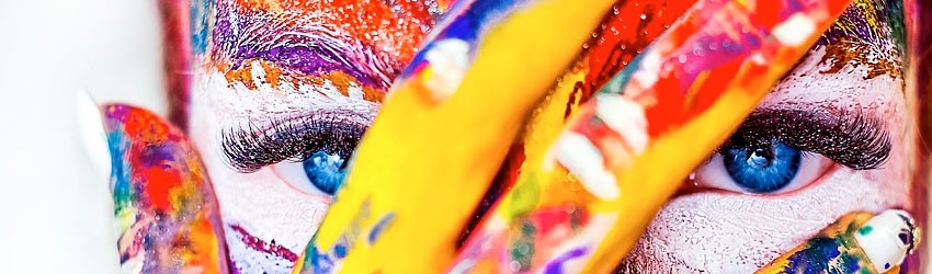 Viso di donna con mano in primo piano pitturata di vari colori
